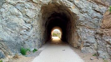 A captivating view of a beautifully carved tunnel through stunning rocky terrain, showcasing natural beauty photo