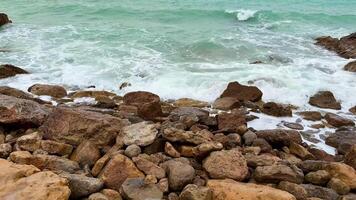Dynamic waves continuously interact with rocks and boulders along a calm and tranquil coastal environment photo