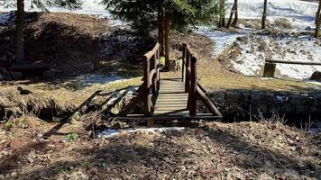 A quaint little wooden bridge is nestled in a serene snowy forest, making it perfect for leisurely winter strolls photo
