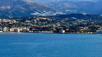 The stunning scenery of the shoreline showcases a tranquil sea, accompanied by majestic mountains in the background video