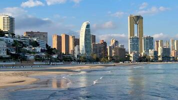 Discover the breathtaking skyline of Benidorm, featuring its iconic highrises alongside tranquil beach waters video