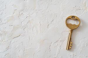 golden key on textured white plaster background, evoking simplicity and elegance photo