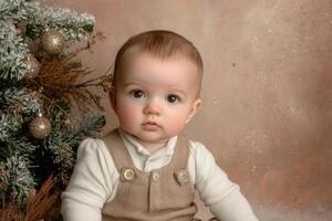 Sweet baby sitting near decorated Christmas tree, looking curious and joyful photo