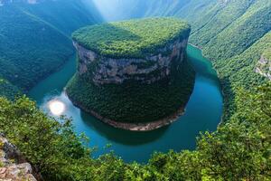 a large green mountain with a river in the middle photo