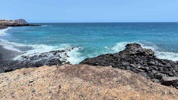 Stunning ocean landscape that showcases powerful waves crashing against a rocky shore beneath a clear blue sky video