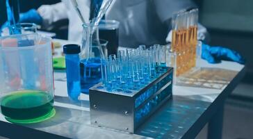 A person in a lab coat is working on a table with test tubes photo
