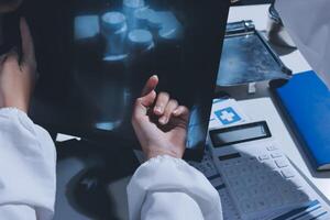 A doctor is examining a x - ray image on a computer photo