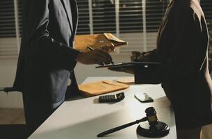 A man and woman in business attire are signing documents photo