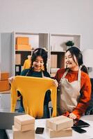 Two women in an office holding up a shirt photo