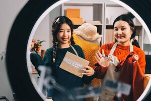 Two women are looking at a mirror while holding a box photo