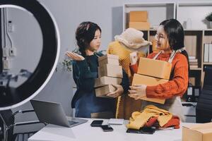 Two women are holding boxes and looking at a camera photo