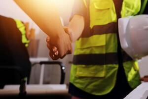 Two people shaking hands in a construction site photo
