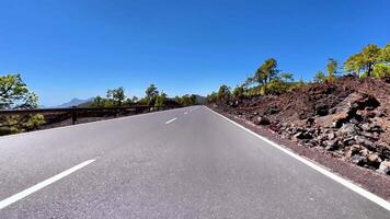 Enjoy breathtaking views of a winding mountain road surrounded by lush greenery and stunning volcanic rocks video
