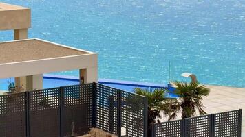 A beautiful landscape with a stunning infinity pool overlooking the ocean, enhanced by swaying palm trees video