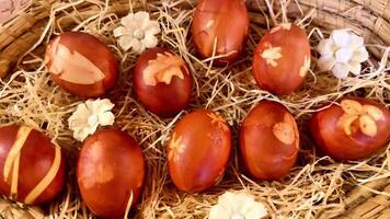 Beautifully decorated red Easter eggs, adorned with lovely floral designs, nestled in a rustic woven basket video