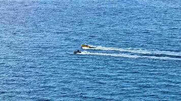Jet skis race through the blue ocean, leaving thrilling wake trails that add to the excitement of the scene video