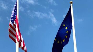 Two flags are on a pole, one is the American flag and the other is the European flag video