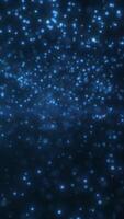 Floating blue particles suspended in a dark ambient space, resembling glowing dust or atmospheric digital snow video