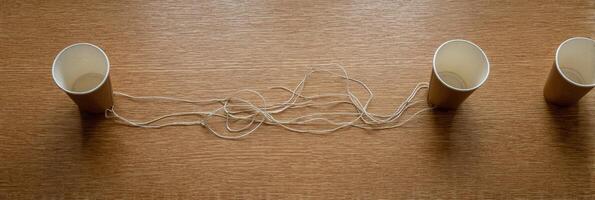 Creative Communication Experiment With Paper Cups and String Between Desks in a Playful Classroom Setting photo