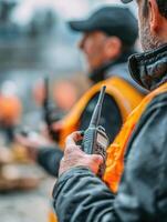 Teamwork in Action as a Man Holds a Walkie-Talkie, Coordinating Efforts in a Dynamic Outdoor Environment photo