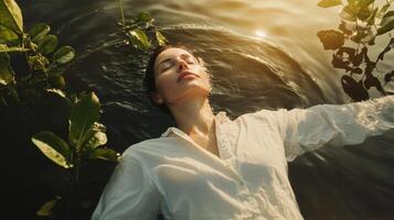 Relaxing woman floating peacefully on calm water surrounded by lush green plants during golden hour photo