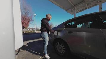 Man refueling his car at a gas station video