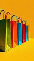 Colorful Shopping Bags Lined up Against a Bright Orange Background photo