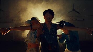 Three young adults dancing in a dusty, backlit environment video
