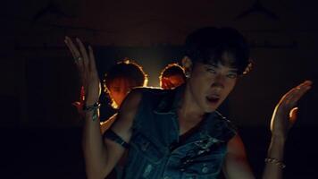 Group of people dancing in a room with atmospheric back light and dust video