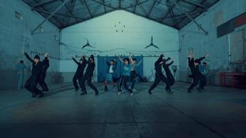 Young male dancer in focus with a group in the background practicing in a dance studio. video