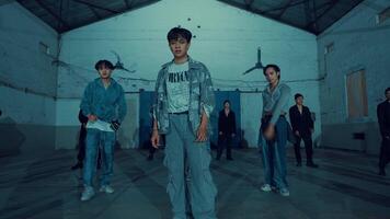 Group of young adults in a moody urban warehouse setting, with a focus on fashion and attitude. video