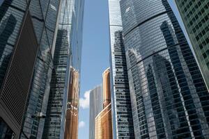 Modern Skyscrapers Reflect Blue Sky and Clouds in Moscow, Showcasing Urban Architecture and Design Amid Urban Development photo