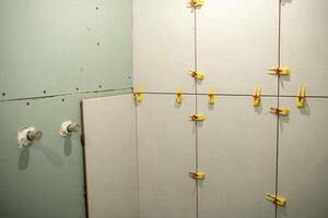 Wall Renovation Project in Progress With Clamps Securing Panels Together in a Construction Space photo