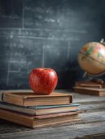 School Desk With Red Apple on Stack of Books and Chalkboard in Background photo