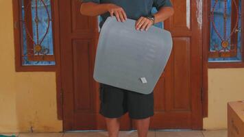 Person Holding a Gray Textured Mat in a Room video