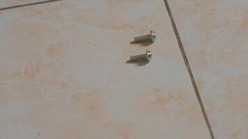 Arranging Metal Screws on Tiled Floor video