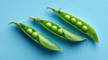 Bright Green Peas in Pods Arranged on a Clean Blue Background Showcasing Natural Freshness and Simplicity photo