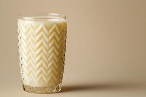 Creamy Beverage in an Ornate Glass Tumbler. A close-up image of a delicious drink served in elegant glassware against a neutral background. photo