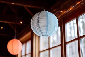 Hanging Paper Lanterns Illuminate a Rustic Cabin Interior. A soft, ambient light fills the space, creating a peaceful and inviting atmosphere. photo