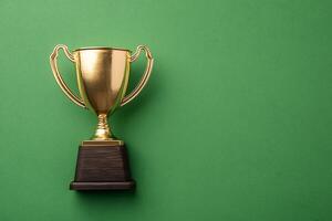 Golden Trophy on Green Background Achievement and Success Symbol. photo