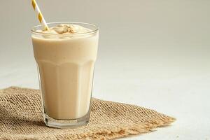 Creamy Oatmeal Smoothie in Glass with Straw. A refreshing and healthy breakfast or snack option. photo