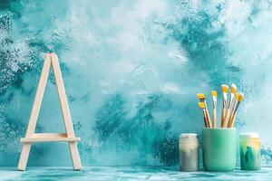 Artistic Still Life Easel, Paintbrushes, and Paints Against a Textured Teal Background. photo