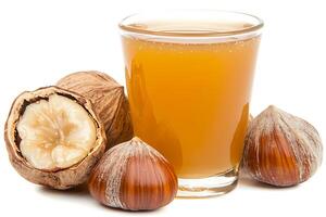Refreshing Hazelnut Beverage with Whole Hazelnuts. A close-up image of a glass of hazelnut juice alongside shelled and unshelled hazelnuts. photo