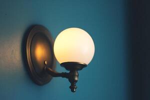 Illuminated Globe Wall Sconce on Teal Wall. A close-up image showcasing a stylish, lit wall-mounted light fixture. photo