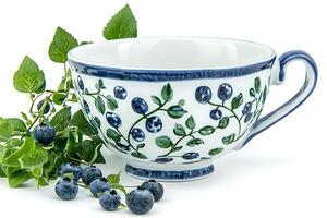 Blue and Green Blueberry Teacup with Fresh Berries. A delightful image showcasing a hand-painted ceramic teacup adorned with a blueberry design, complemented by a sprig of fresh blueberries. photo