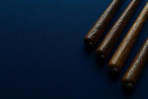 Three Wooden Baseball Bats Arranged on a Dark Blue Background. A Striking Image Ideal for Sports-Related Designs. photo