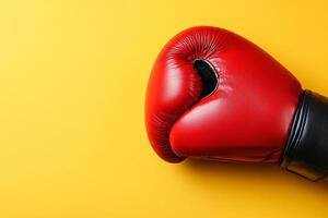 Red Boxing Glove on Yellow Background Sport, Competition, and Strength. photo
