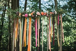Floral Archway with Colorful Ribbons in a Forest Setting. A whimsical and romantic outdoor wedding or event decoration. photo