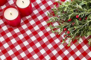 Festive Red and White Gingham Table Setting with Candles and Berries. A charming image perfect for holiday or seasonal designs. photo