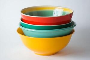 Stack of Colorful Ceramic Mixing Bowls in Yellow, Teal, and Red. A vibrant image perfect for kitchenware, home goods, or food-related content. photo